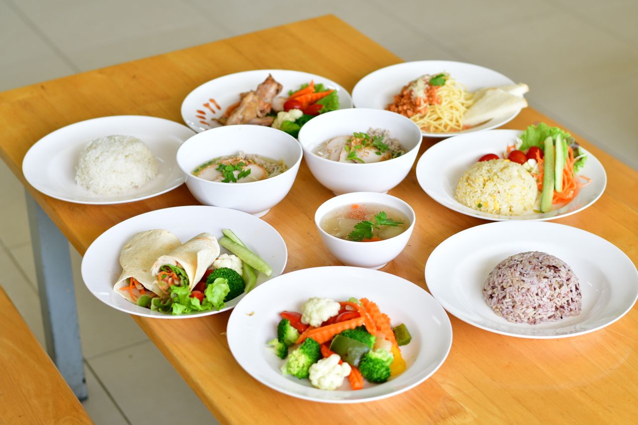 A variety of nutritious dishes displayed on a wooden table, showcasing diverse healthy meals.